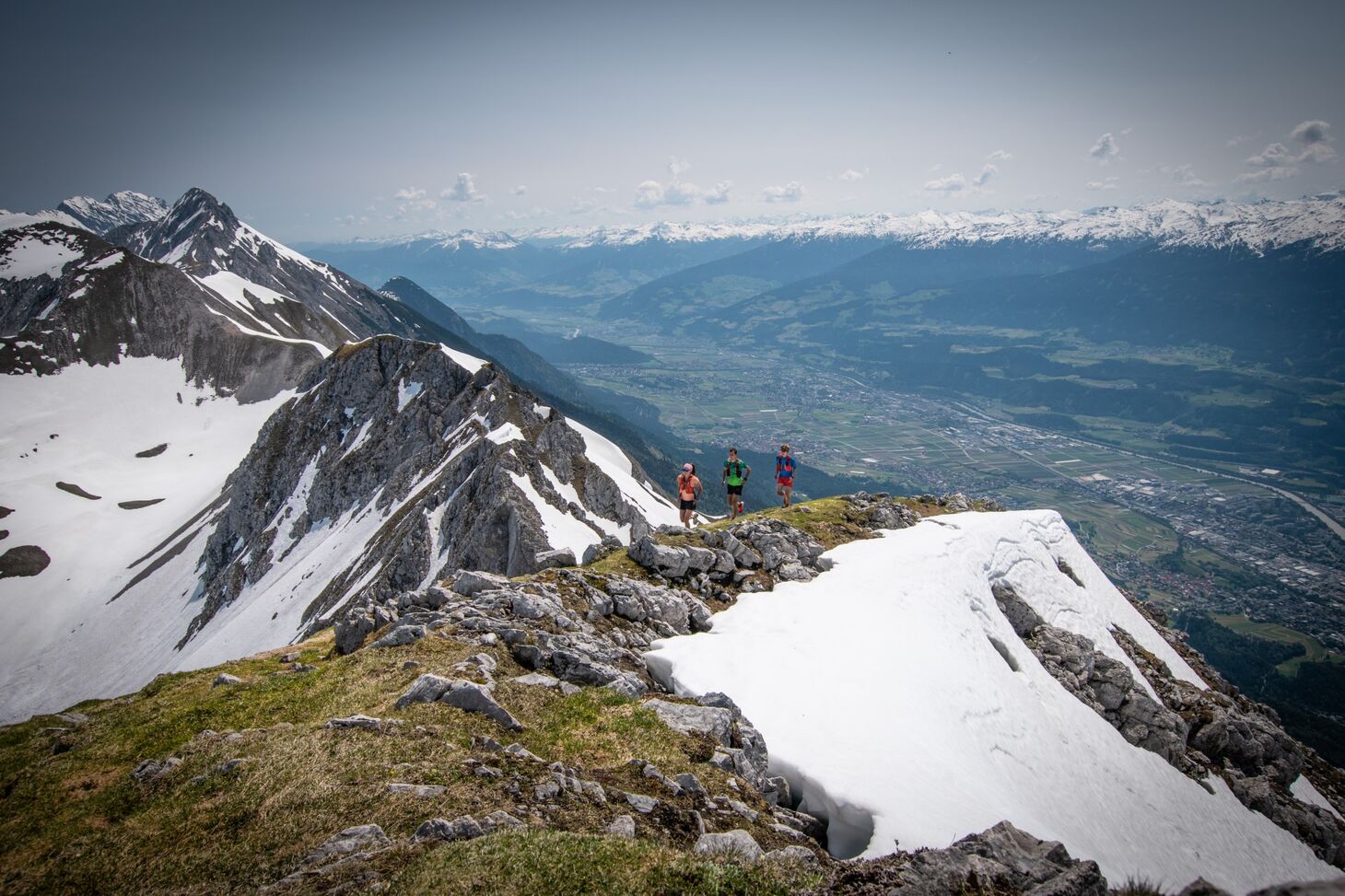 Trail runners on a ridge overlooking a valley